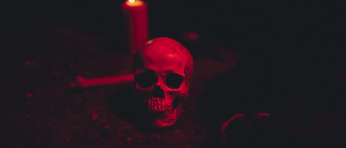calavera-y-vela-en-una-luz-roja-oscura