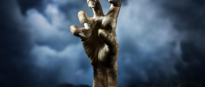 mano-de-zombie-aterrador-desde-el-suelo-por-la-noche